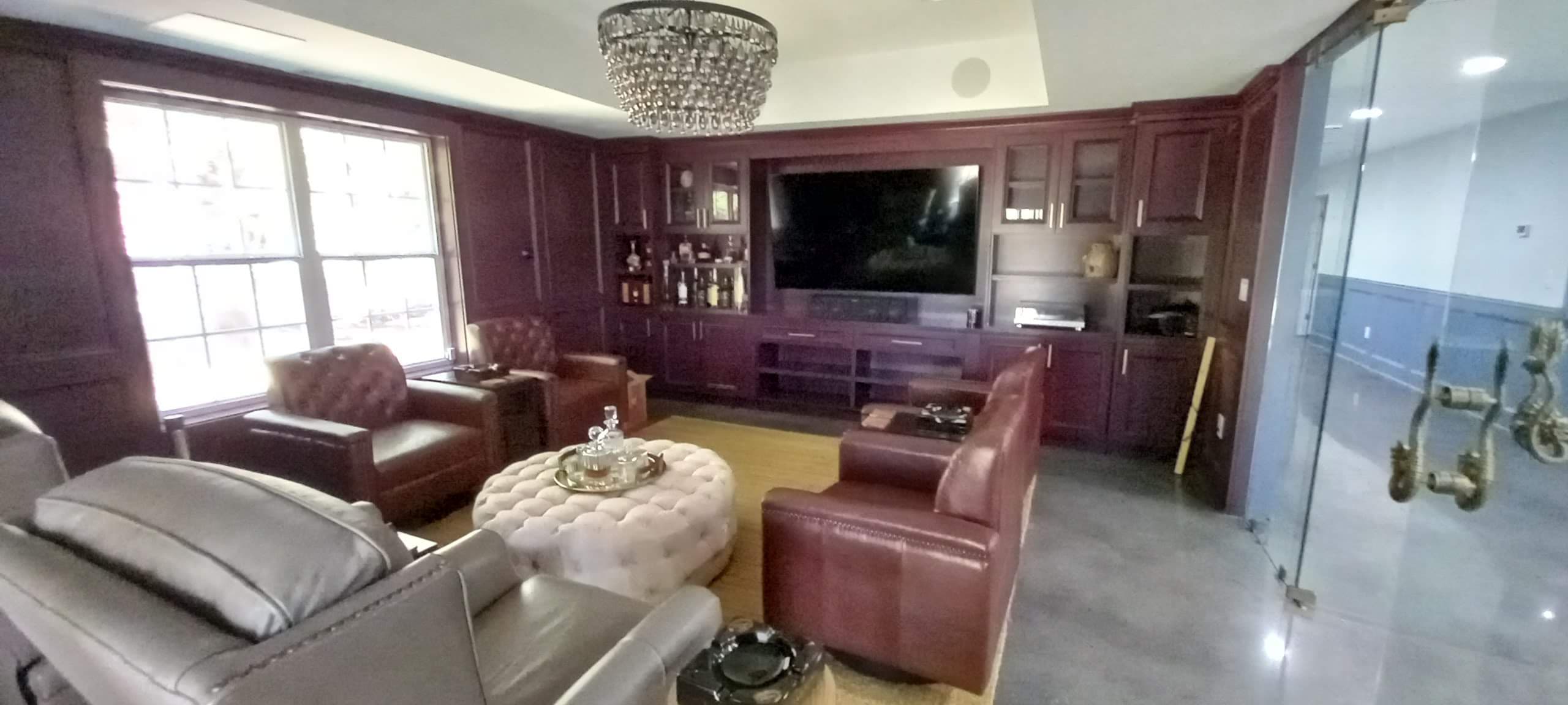 Dark wood entertainment room with a custom built-in wall unit and bar by Hdez Gabinets in Atlanta