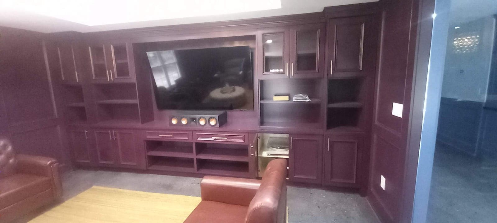 Burgundy wood built-in TV unit with shelving and glass doors by Hdez Gabinets