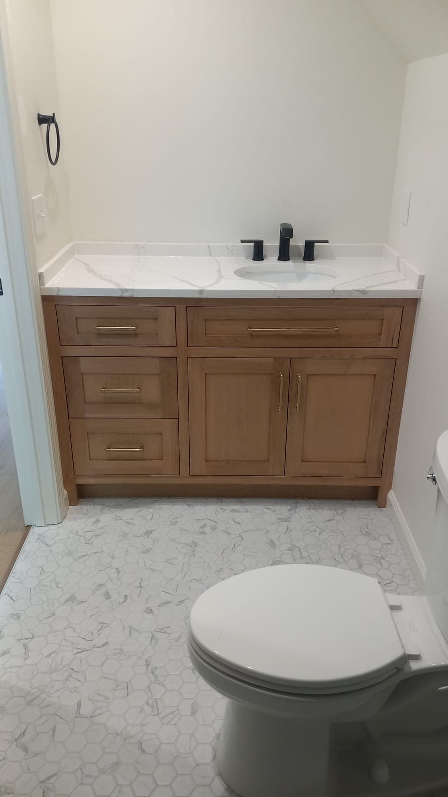 Custom wood vanity with drawers and a white quartz top built by Hdez Gabinets