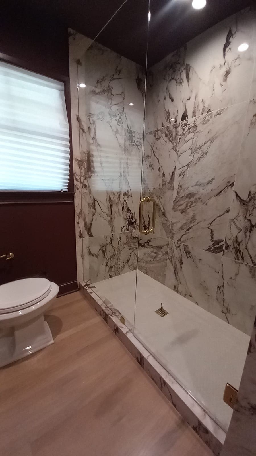 Walk-in shower with large marble-look slab tile with purple veining, remodeled by Hdez Gabinets