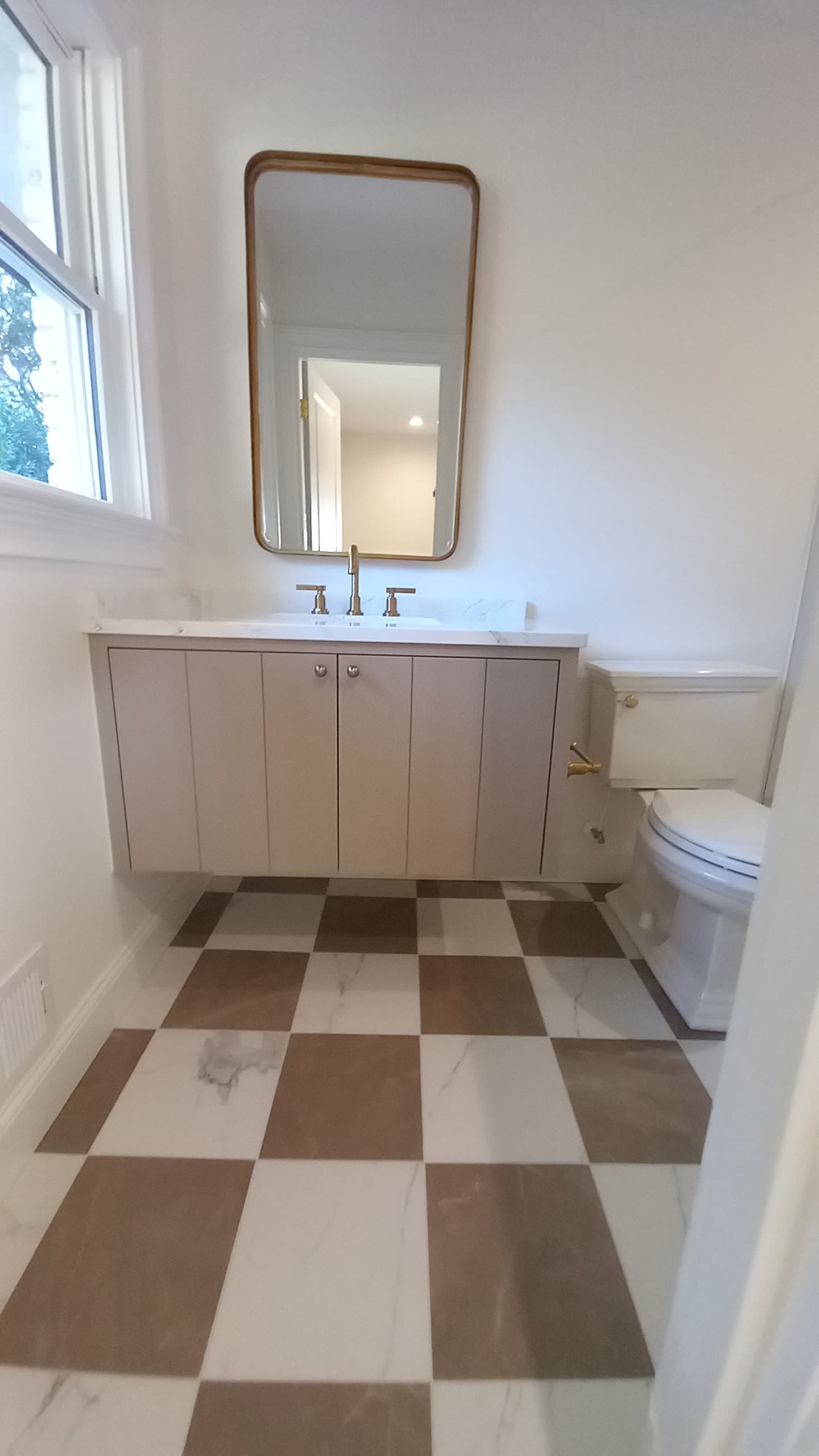 Floating custom vanity with a checkered tile floor built by Hdez Gabinets